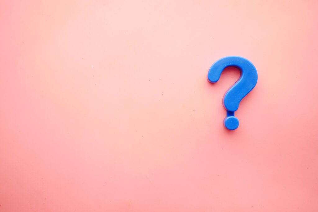 A blue question mark on a pink background. 